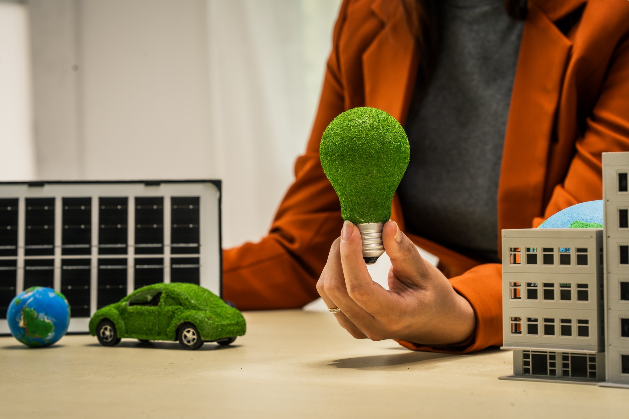 A businesswoman working at a desk in sustainable urban development, promoting eco-friendly