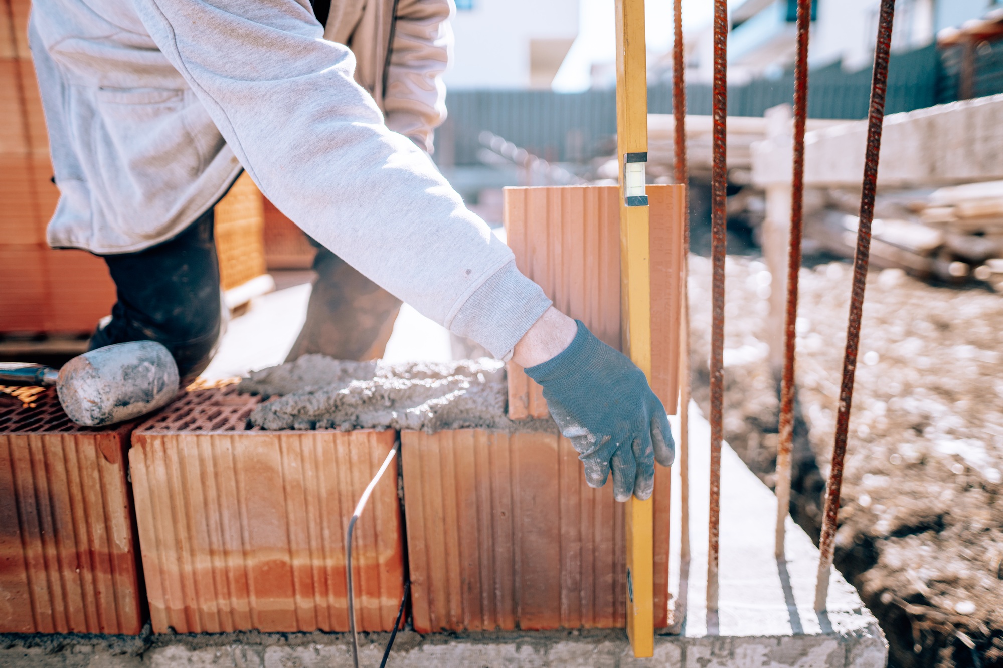 Bricklayer industrial worker installing brick masonry